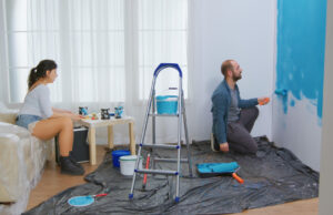 Residential Waterproofing Contractors for Premium Home Renovation A man and woman collaboratively painting a room blue, representing a project by residential waterproofing contractors.