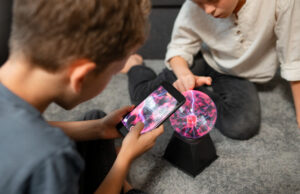 Why Psychic Readings Are Essential for Modern Life Clarity Two boys playing on the floor with a phone, laughing and interacting, highlighting their joyful friendship.