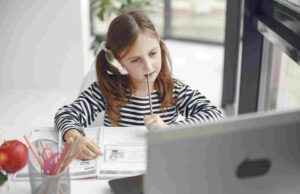 How to Choose the Best 11 Plus Tutor in Bexley A young student looking thoughtfully at a laptop and notebook.