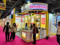 How Exhibition Brands Grow with 3D Stall Design in Dubai Trade show booth for Sanjeevani Basmati Rice with bright yellow and white design, product displays, and visitors walking around.