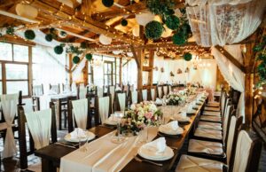 The Blueprint for Unforgettable Events: Balancing Strategy and Creativity Expert event planners in Dubai designing a rustic indoor wedding venue with floral decor and fairy lights.